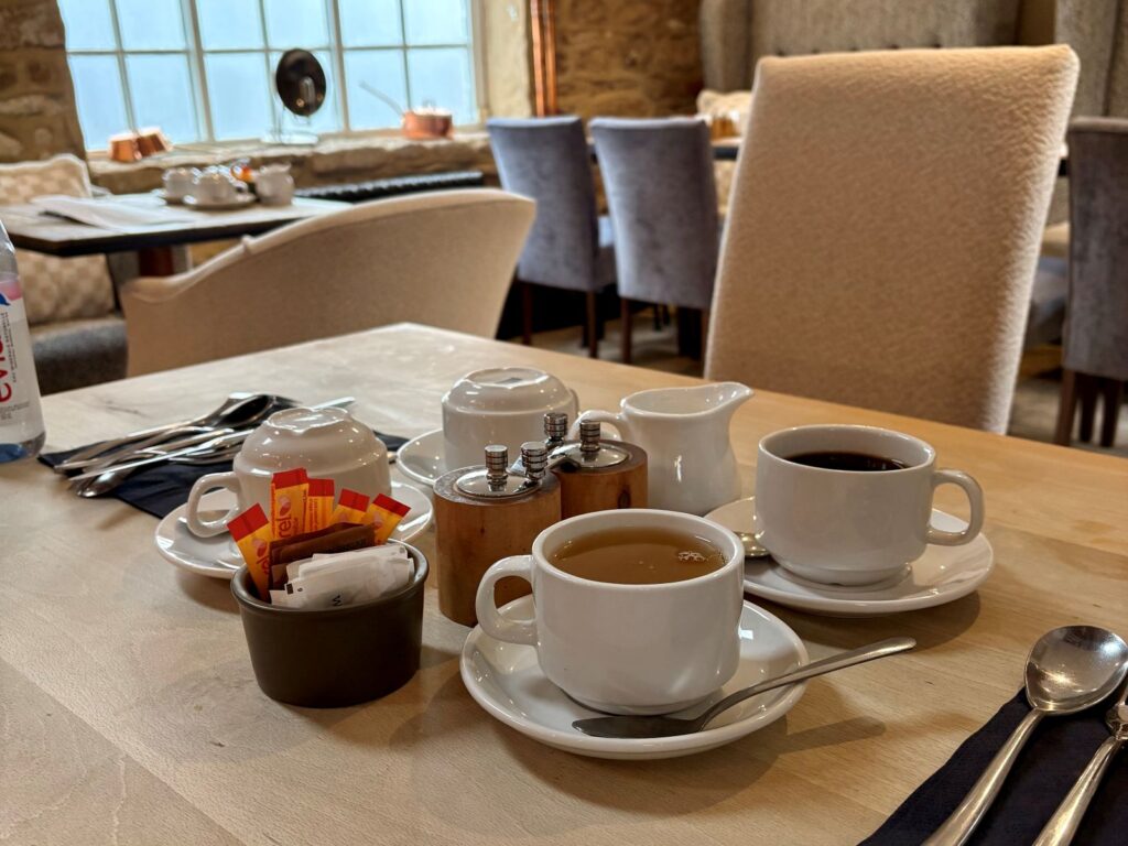 Tea and coffee at a table ready to order a gluten-free travel breakfast