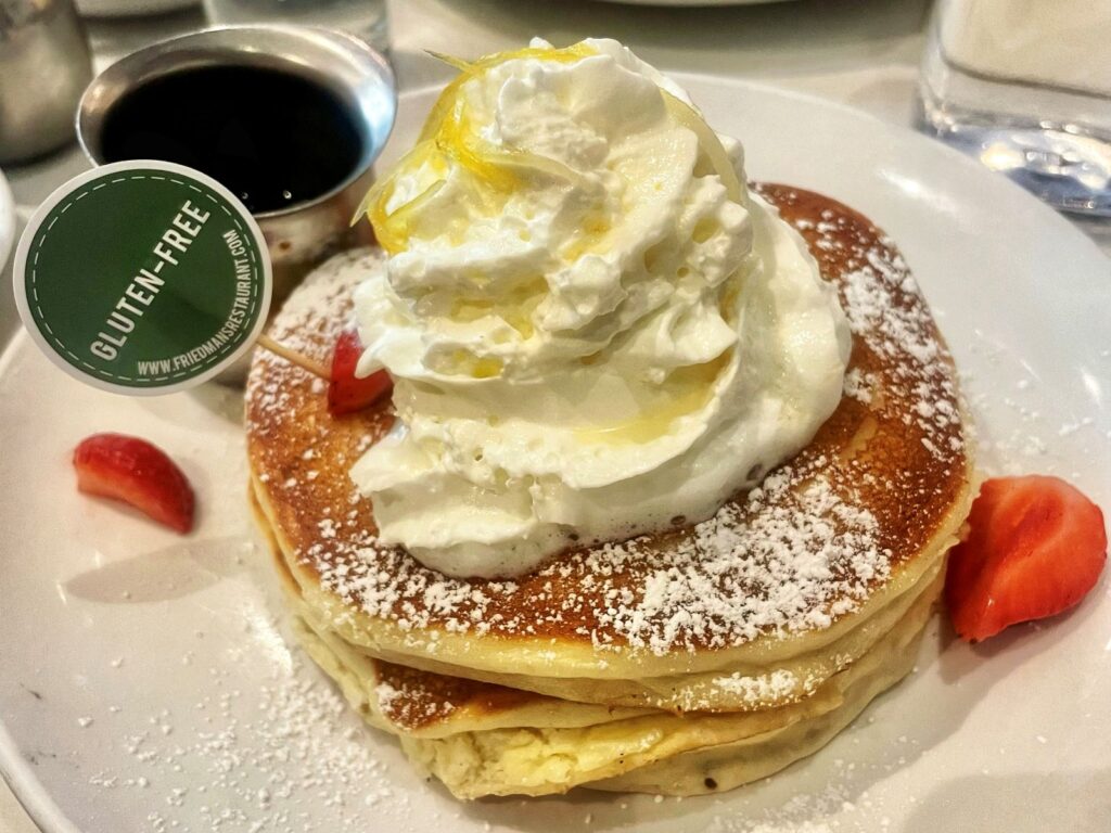 A stack of pancakes with a gluten-free label stuck in the top