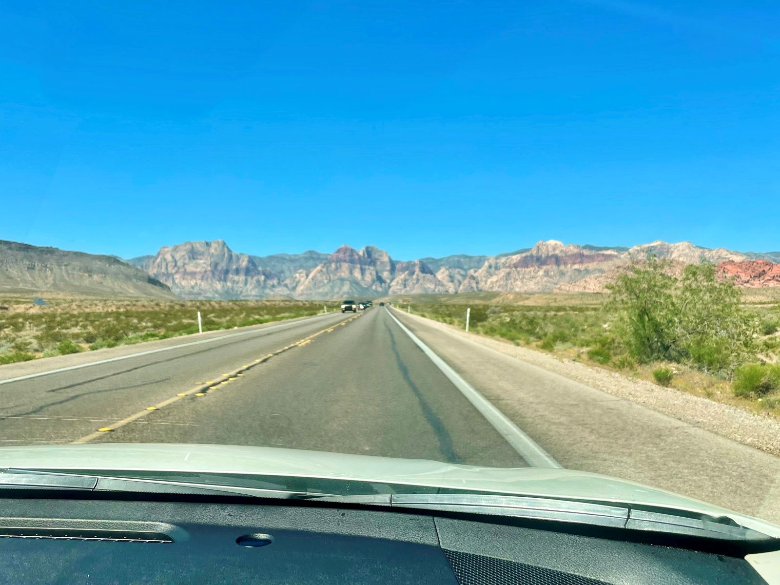 View from passenger seat through car window towards Red Rock Canyon National Conservation Area