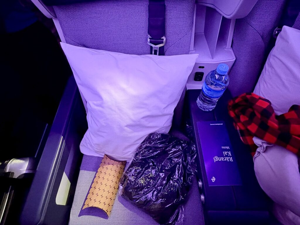 Amenities on seat pre take off on long-haul flight with water to stay hydrated and stay healthy on a long-haul flight