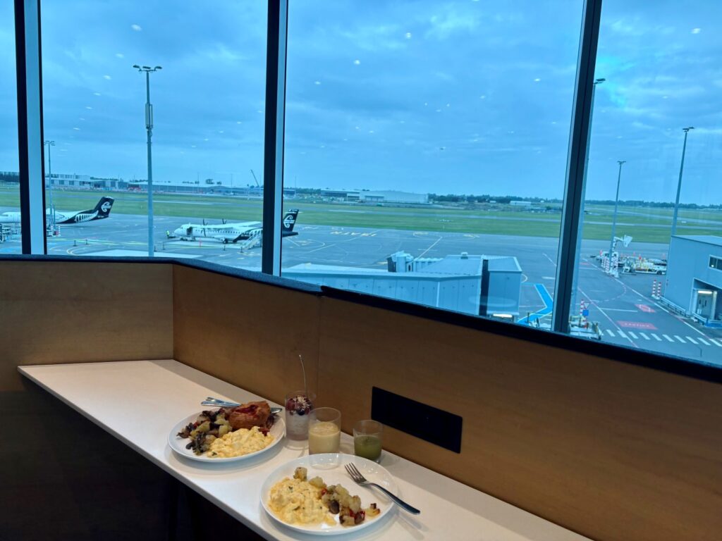 Airport lounge food plated up with a view of the airport in the distance