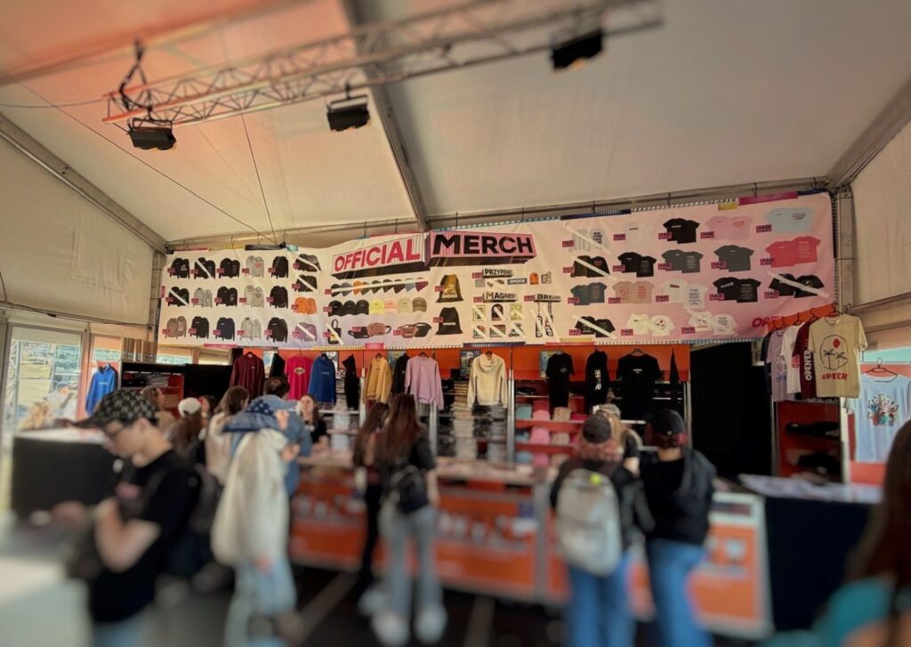 Inside a festival merch tent already with the idea to buy a t-shirt to help with festival financial anxiety