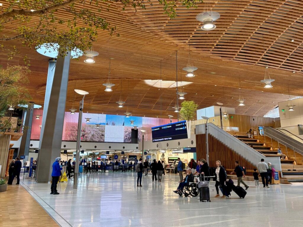 A wide shot of many travellers walking through Portland International Airport