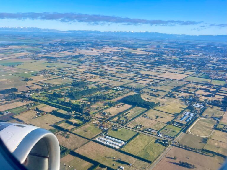 View out of plane window with lots of paddocks in view