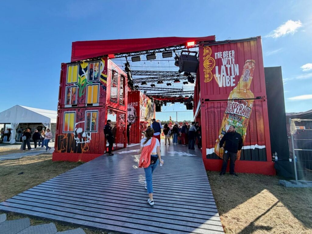 A woman walking into a sponsored area at Open'er festival wearing a practical outfit for the weather