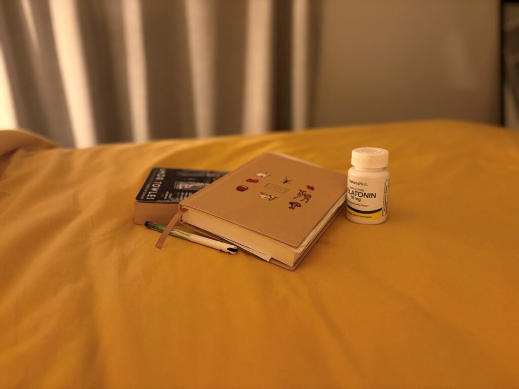 Melatonin, diary and book on bed in evening to help support jet lag recovery