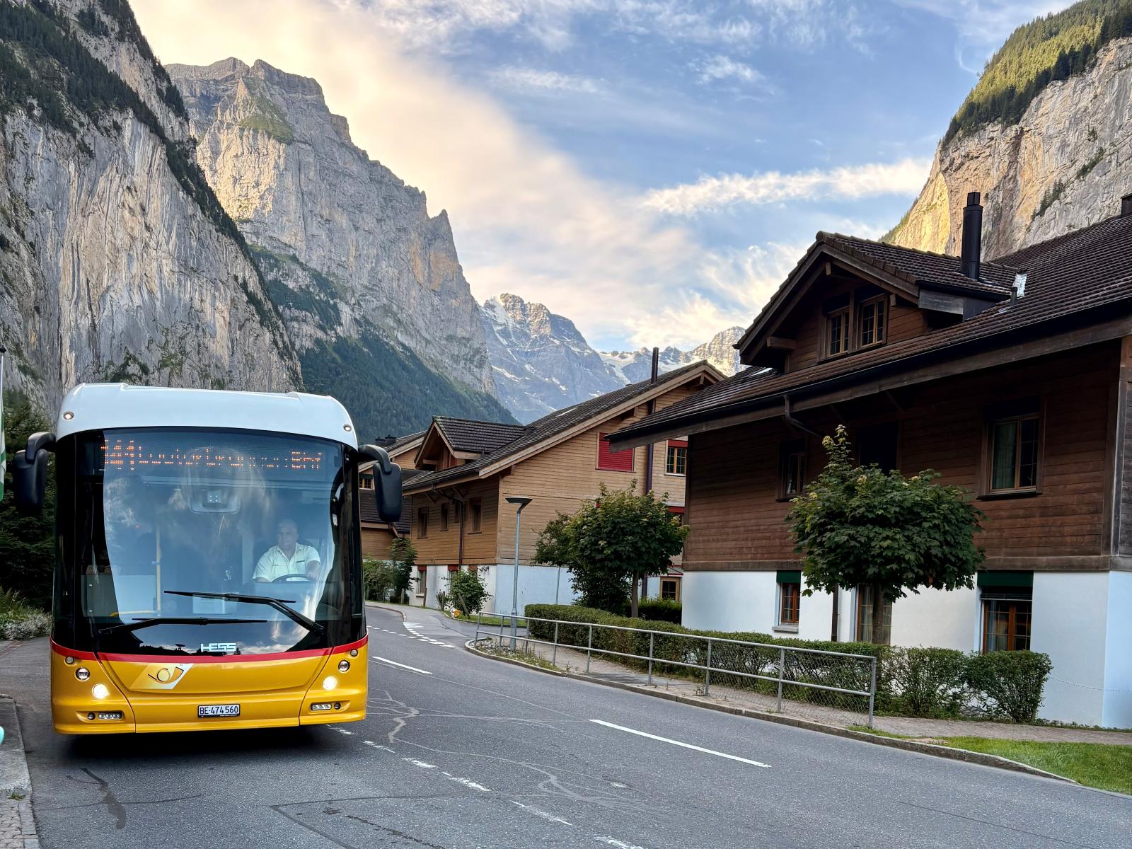 Using public transport in Switzerland bus pulling up with mountains in background