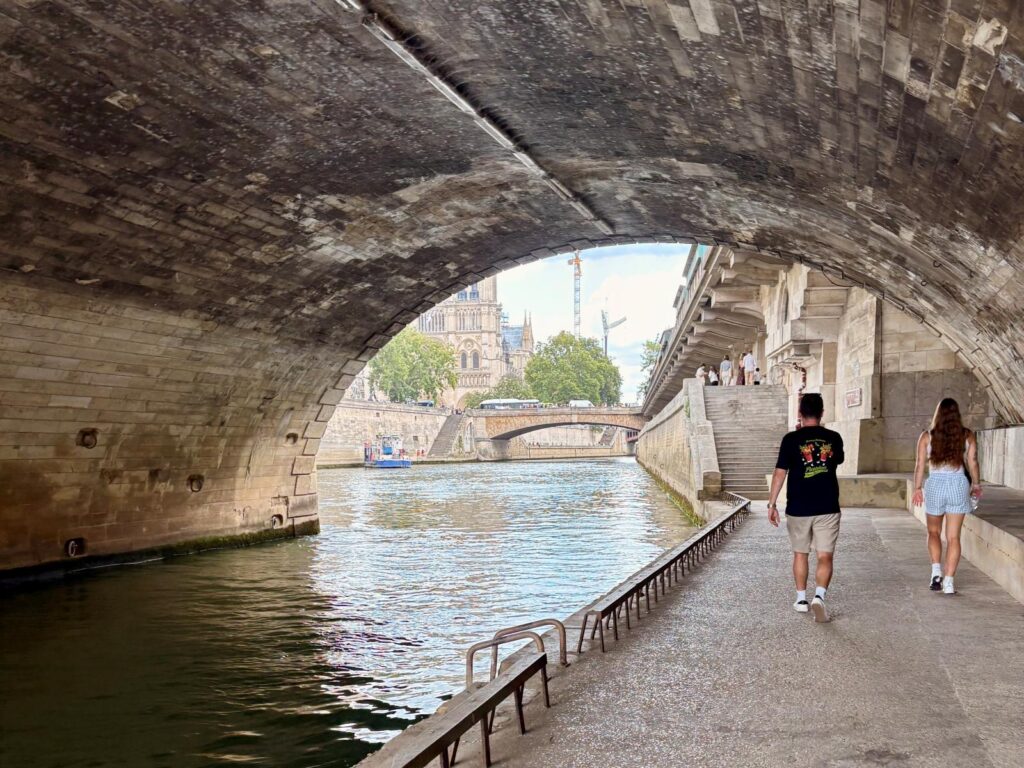 People walking alongside the Seine River in Paris