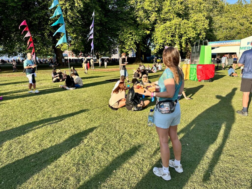 A person stands with food at a festival attempting to stay energised at a festival with regular eating