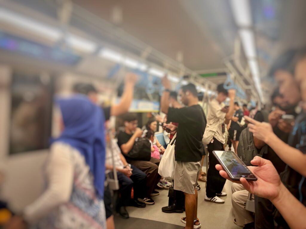 People on phones while travelling on public transport in Singapore