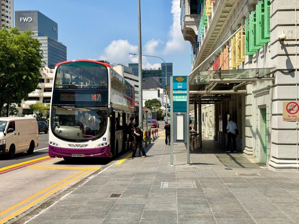 Bus at bus stop in Singapore, an example of using Singapore public transport