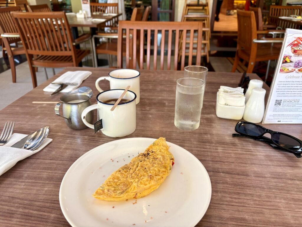 Omlette and coffee on a table at a breakfast buffet