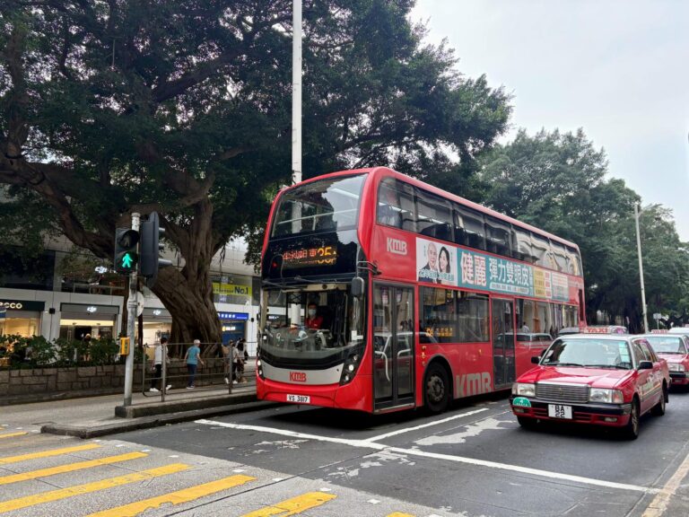 A bus and a taxi on a road in central Hong Kong