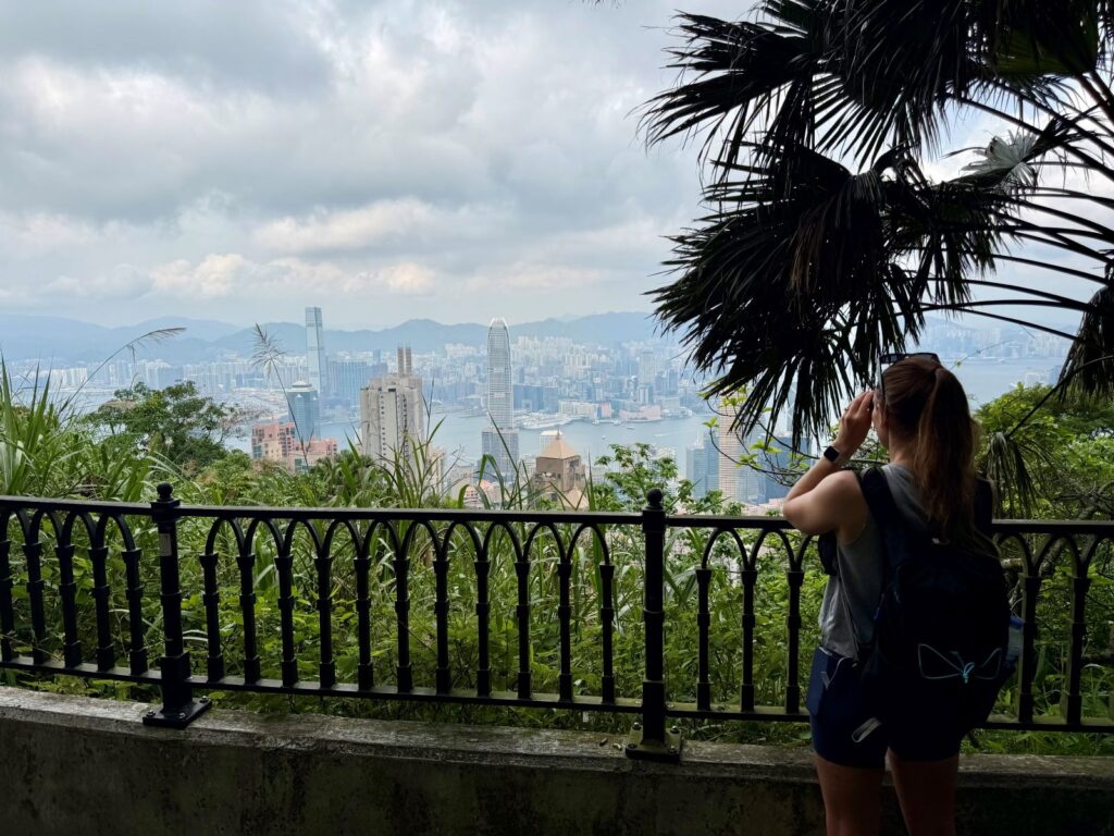 Woman looking through bincoculars at the view of Hong Kong