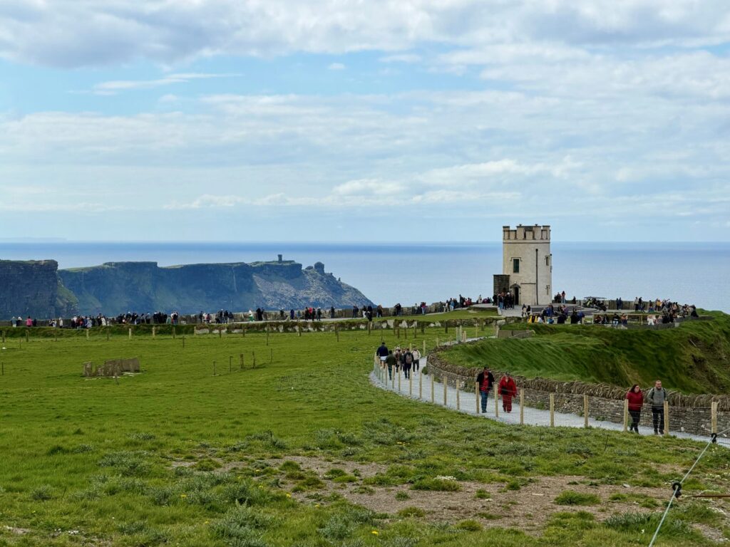 Looking back at the crowds at the Cliffs of Moher, experiencing green spaces in Ireland and stunning landscapes