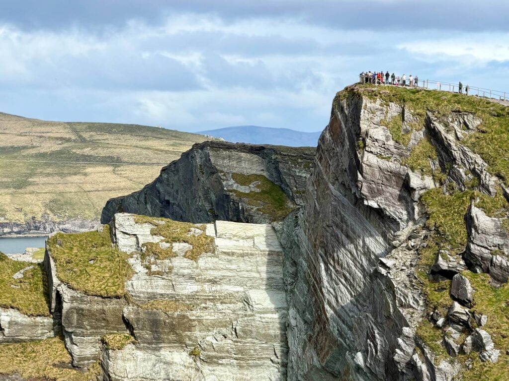 A view of the Cliffs of Kerry, Ireland, with people just visible in the distance