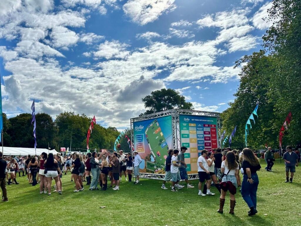 Festival goers look at entrance signage to decide where to go