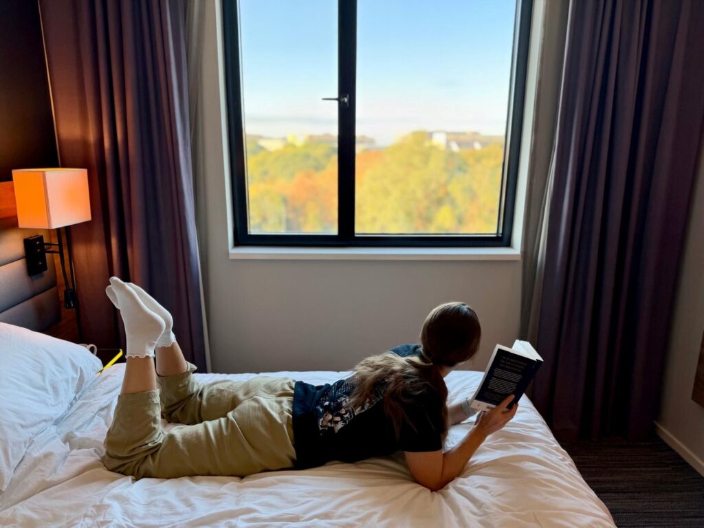 A woman reading a book on holiday in a hotel room